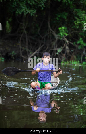 Junge in Einbaum auf dem San Miguel Caño, Obere Amazon River Basin, Loreto, Peru Stockfoto