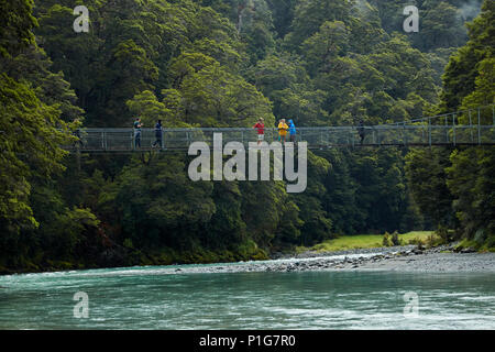 Touristen auf Fußgängerbrücke über Makarora River, Blue Pools, Mount Aspiring National Park, den Haast Pass, in der Nähe der Makarora, Otago, Südinsel, Neuseeland Stockfoto