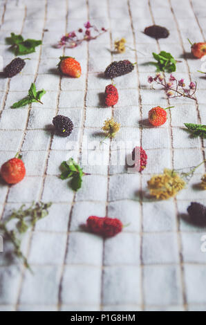 In der Nähe von Mulberry Obst und Erdbeeren, frische Beeren Obst und Minze auf weißem Stoff. Stockfoto