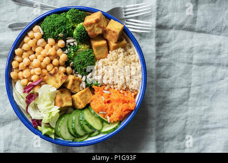 Salatschüssel mit Quinoa, Tofu, Kichererbsen und Gemüse auf Leinen Background. Ansicht von oben, kopieren Platz für Text Stockfoto