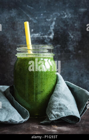 Grüne Smoothie in einer Glasflasche. Detox, veganes Essen und Reinigung Konzept. Vertikale Zusammensetzung Stockfoto