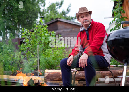 Grill Zeit. Europäischen Mann in hat Warten auf Gegrilltes. Stockfoto
