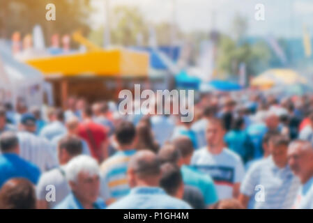 Abstrakte Messe verschwommenen Hintergrund mit Masse Menschen aus der konzentrieren. Überfüllte Outdoor Open Air Festival zeigen Ausstellung Kulisse. Stockfoto