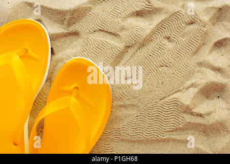 Gelber Strand flip flops auf Sand, Ansicht von oben mit der Kopie Raum Stockfoto