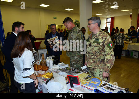 Us-Armee Oberst Steve Marken, U.S. Army Garrison Italien Commander (Mitte), lernt über eine Veranstaltung mit Vertretern aus der Stadt Camisano, während der achten jährlichen Treffen der Bürgermeister bei den Goldenen Löwen Conference Center auf Caserma Ederle, Vicenza, Italien. Die Veranstaltung ist eine informelle fair, dass Gastgeber Bürgermeister, Ratsmitglieder, sowie kulturelle und touristische Vertreter der Italienischen Gemeinden in den Provinzen Vicenza und Padua. 27.10.2016. (U.S. Armee Foto von visuellen Informationen Spezialist Antonio Bedin-/freigegeben) Stockfoto
