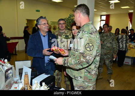 Us-Armee Oberst Steve Marken, U.S. Army Garrison Italien Commander, erhält die Veneto guidon von Giuseppe Maddalena, Camisano stellvertretender Bürgermeister, während der achten jährlichen Treffen der Bürgermeister bei den Goldenen Löwen Conference Center auf Caserma Ederle, Vicenza, Italien. Die Veranstaltung ist eine informelle fair, dass Gastgeber Bürgermeister, Ratsmitglieder, sowie kulturelle und touristische Vertreter der Italienischen Gemeinden in den Provinzen Vicenza und Padua. 27.10.2016. (U.S. Armee Foto von visuellen Informationen Spezialist Antonio Bedin-/freigegeben) Stockfoto