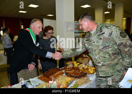 Us-Armee Oberst Steve Marken, U.S. Army Garrison Italien Commander, grüßt Rigoni Giancarlo, Sovizzo Bürgermeister, während der achten jährlichen Treffen der Bürgermeister bei den Goldenen Löwen Conference Center auf Caserma Ederle, Vicenza, Italien. Die Veranstaltung ist eine informelle fair, dass Gastgeber Bürgermeister, Ratsmitglieder, sowie kulturelle und touristische Vertreter der Italienischen Gemeinden in den Provinzen Vicenza und Padua. 27.10.2016. (U.S. Armee Foto von visuellen Informationen Spezialist Antonio Bedin-/freigegeben) Stockfoto