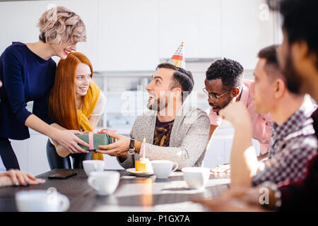 Junge bärtige Mann mit Bithday cap immer willkommene Geschenk Stockfoto