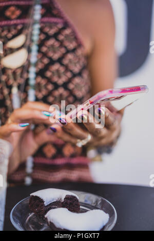 Nahaufnahme der schwarze Frau mit einem Mobiltelefon mit eine schöne Maniküre Stockfoto