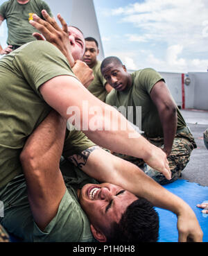 USS SOMERSET, Pazifischer Ozean (Okt. 2010) 28, 2016) - kpl. Jesus Diaz wehrt sich gegen Lance Cpl. Ivan Giron beim Marine Corps Martial Arts Program Training an Bord der USS Essex (LPD 25) Okt. 28, 2016. Die Marines sind derzeit nach vorne an Bord der Schiffe der Makin Island Amphibious Ready Gruppe/11 Marine Expeditionary Unit bereitgestellt und Segeln durch die Indo-Asia - Pacific Theater, und in der fünften Flotte Bereich der Operationen. Giron ist ein Tank crewman und Diaz ist ein Tank Commander; beide sind mit Tank Platoon, Bataillon Landung Team 1 Mrd., 4 Marines, 11 Marine Expeditionary Unit Stockfoto