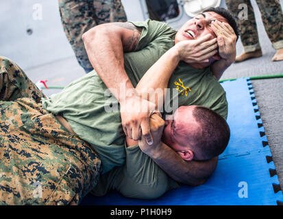 USS SOMERSET, Pazifischer Ozean (Okt. 2010) 28, 2016) - Lance Cpl. Ivan Giron verteidigt gegen einen Head Lock von Cpl. Jesus Diaz beim Marine Corps Martial Arts Program Training an Bord der USS Essex (LPD 25) Okt. 28, 2016. Die Marines arbeitete an mehreren Boden kämpfen Verteidigungstechniken und Grappling Drills, ihre militärische Bereitschaft aufrecht zu erhalten, während der Durchfahrt über dem westlichen Pazifik. Giron ist ein Tank crewman und Diaz ist ein Tank Commander; beide sind mit Tank Platoon, Bataillon Landung Team 1 Mrd., 4 Marines, 11 Marine Expeditionary Unit. (U.S. Marine Corps Foto von gunnery Sgt. Robert Bro Stockfoto