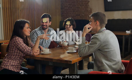 Vier Freunde sind, zusammen zu spielen, die ich im Cafe am Stockfoto