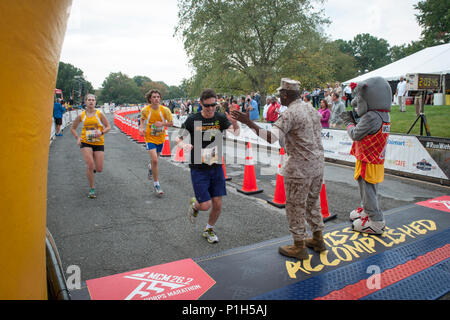 Us Marine Corps Ronald L. Grün, 18 Sergeant Major des Marine Corps, high-fives Läufer, wie sie die Ziellinie bei der 41st jährlichen Marine Corps Marathon, Arlington, Va., Nov. 30, 2016. Bekannt als "Der Marathon, "die 26,2 Kilometer rennen, dem drittgrößten Marathon in den Vereinigten Staaten, zieht mehr als 30.000 Teilnehmer jährlich. (U.S. Marine Corps Foto von Lance Cpl. Micha R. Pierce) Stockfoto