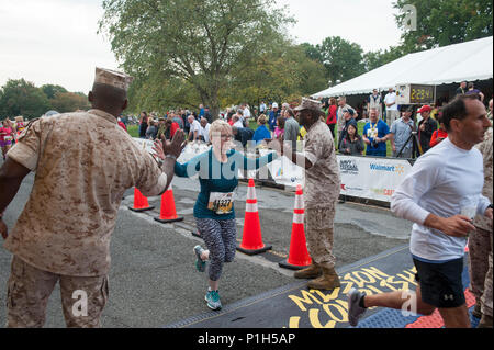 Us Marine Corps Ronald L. Grün, 18 Sergeant Major des Marine Corps und Sgt. Maj Charles Willliams, Sergeant Major der Marine Corps Base Quantico, hohe - fünf Angelique Rose wie erreicht sie die Ziellinie der 41. jährlichen Marine Corps Marathon, Arlington, Va., Nov. 30, 2016. Bekannt als "Der Marathon, "die 26,2 Kilometer rennen, dem drittgrößten Marathon in den Vereinigten Staaten, zieht mehr als 30.000 Teilnehmer jährlich. (U.S. Marine Corps Foto von Lance Cpl. Micha R. Pierce) Stockfoto