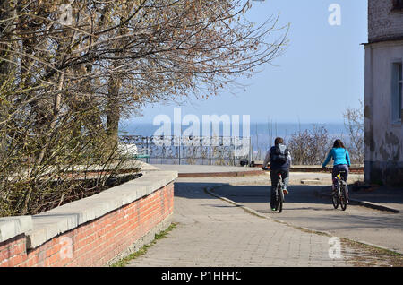 Ein junges Paar von bikern Fahrt durch leere Straßen bei klarem Wetter. Der Mann und das Mädchen gehen auf Fahrräder Stockfoto