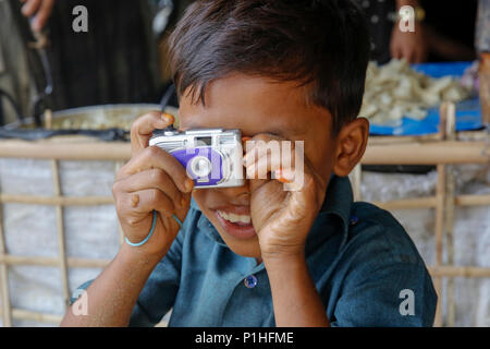 Ein Rohingya Flüchtlinge Junge mit seinem Spielzeug Kamera auf Kutupalong Flüchtlingslager bei Ukhiya in Cox's Bazar, Bangladesch Stockfoto