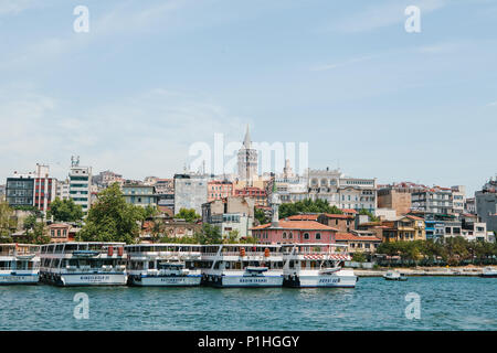 Istanbul, 17. Juni 2017: Viele Fähren und Passagierschiffe vor der Küste. Im Hintergrund gibt es verschiedene Gebäude und der Galata Turm. Transport von Passagieren durch Wasser Stockfoto