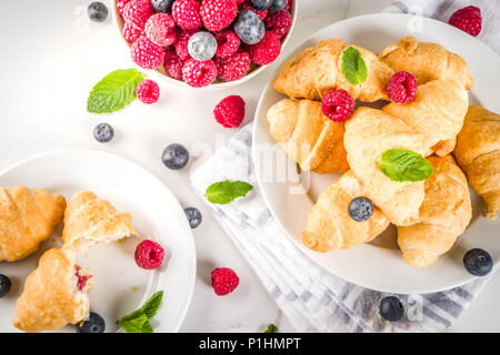 Sweet Summer Dessert hausgemachte gebackene Mini-croissants mit Beeren Marmelade, serviert mit Kaffee, frischen Himbeeren, Heidelbeeren und Minze. Auf einem weißen Marmor tisch Stockfoto