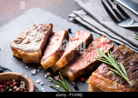 Rindersteak. Gegrilltes Roastbeef Steak auf Schneidebrett mit nerbs und Gewürzen. Close Up. Stockfoto