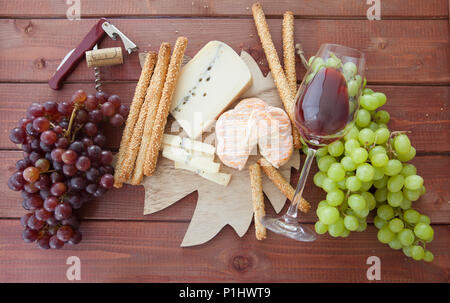 Käseplatte mit Rotwein und frischen Weintrauben Stockfoto
