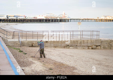 Metall detectorist entlang der High Water Mark suchen am Strand von Clacton-on-Sea. Stockfoto