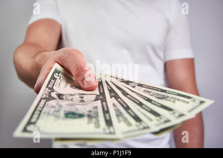 Ein junger Mann mit fünf Dollar Bill, es geben - auf weißem Hintergrund Stockfoto