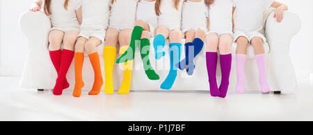 Kinder tragen bunte Regenbogen Socken. Kinder Schuhe Kollektion. Vielzahl von gestrickte Kniestrümpfe und Strumpfhosen. Kind Kleidung und Bekleidung. Kid fash Stockfoto