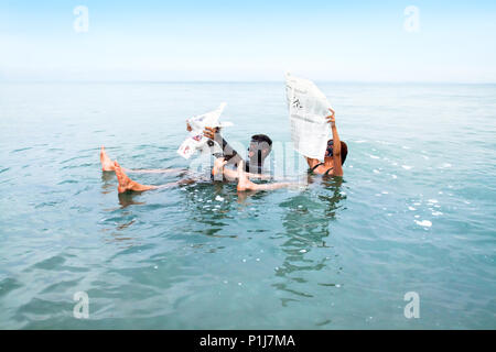 MADABA, Jordanien - 22. SEPTEMBER: die Menschen können Schwebend an der außergewöhnlich Dichte salzige Wasser des Toten Meeres beim Lesen, Septemter 22. 2010. Madaba, J Stockfoto