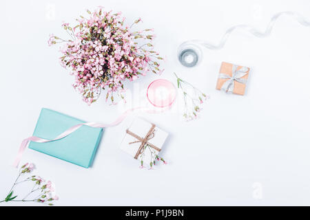 Feminine festlichen rosa Flachbild Layout mit Blumenstrauß, Bänder und Geschenkboxen. Feier Einrichtung Zusammensetzung auf weißem Hintergrund. Stockfoto