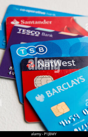 Fünf Visa-Debitkarten auf einem Stapel auf weißem Hintergrund, darunter Tesco, TSB, Barclays, Co-op, NatWest und Santander. Stockfoto