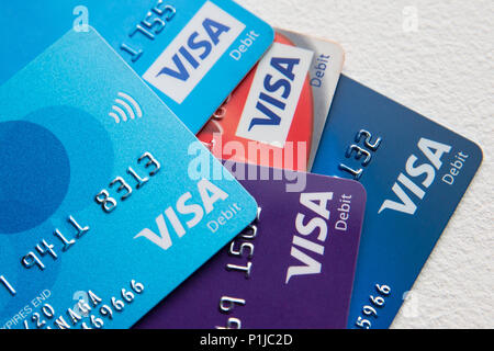 Fünf Visa-Debitkarten auf einem Stapel auf weißem Hintergrund, darunter Tesco, TSB, Barclays, Co-op, NatWest und Santander. Stockfoto