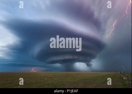 Supercell mit Blitz bei Sonnenuntergang über einem Feld in der Nähe von Vega, Oldham County, Texas, USA Stockfoto