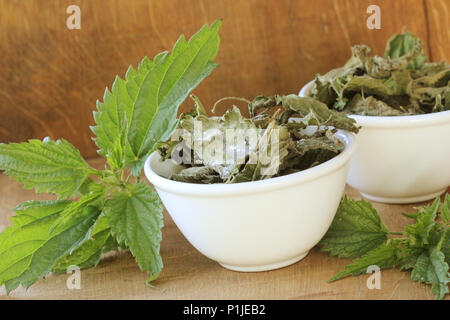 Brennnessel Chips in der Schüssel und frische Brennnessel auf Tisch. Stockfoto