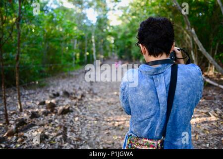 Mutter nimmt Bilder von ihren Töchtern gehen durch einen Wald, Paluma Range National Park, Rollingstone QLD, Australia Stockfoto