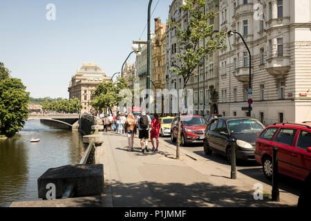 Wandern entlang der Moldau mit traditionellen aprtment Gebäude entlang der Straße und Nationaltheater Gebäude in der Ferne in Prag, Tschechische Republik Stockfoto