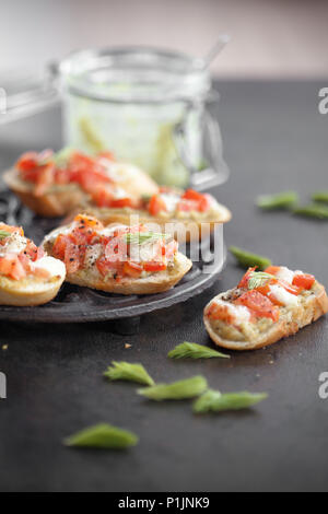 Italienische Bruschetta mit Fichte sprießen, Pesto, Tomaten und Mozzarella Stockfoto