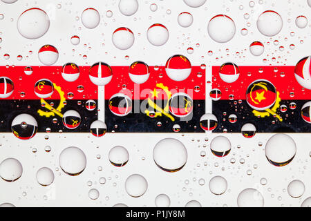 Flagge von Angola hinter ein Glas mit Regentropfen fallen. Stockfoto