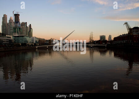 Die Puente de La Mujer Fußgängerbrücke in Puerto Madero in Buenos Aires, Argentinien in der Abenddämmerung. Stockfoto