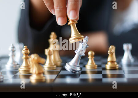 Nahaufnahme der Hand des Business woman beweglichen goldenen Schach zu besiegen und Silver King Schach auf weißen und schwarzen Schachbrett für geschäftliche Herausforderung co töten Stockfoto