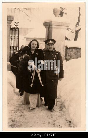 PRAG, TSCHECHOSLOWAKISCHE SOZIALISTISCHE REPUBLIK - UM 1950s: Ein Vintage-Foto zeigt das Brautpaar nach der Trauung in der Kirche. Die Hochzeitszeremonie findet im Winter statt. Altes Schwarz-Weiß-Foto, 1950s. Stockfoto