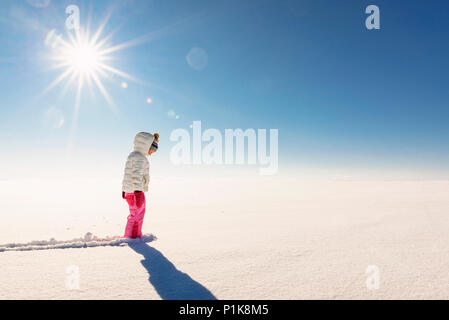 Stehendes Mädchen in einer verschneiten Landschaft im ländlichen Raum Stockfoto