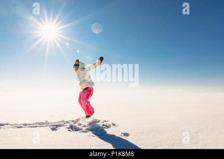 Mädchen springen der Luft in einer verschneiten Landschaft im ländlichen Raum Stockfoto