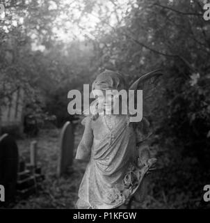 Statue eines Kindes Engel mit einem fehlenden arm, Highgate Cemetery, Hampstead, London, 1987. Artist: John Gay. Stockfoto