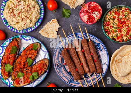 Klassische Kebabs, tabbouleh Salat, Baba ganush und gebackene Auberginen mit Soße. Traditionelle orientalische oder arabische Gericht. Ansicht von oben. Stockfoto