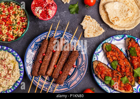 Klassische Kebabs, tabbouleh Salat, Baba ganush und gebackene Auberginen mit Soße. Traditionelle orientalische oder arabische Gericht. Ansicht von oben. Stockfoto