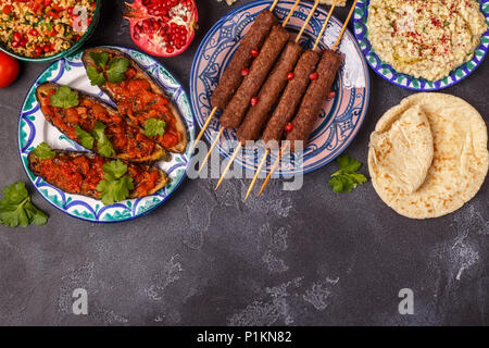 Klassische Kebabs, tabbouleh Salat, Baba ganush und gebackene Auberginen mit Soße. Traditionelle orientalische oder arabische Gericht. Ansicht von oben. Stockfoto