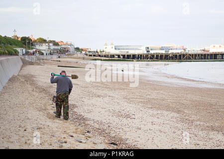 Metall detectorist entlang der High Water Mark suchen am Strand von Clacton-on-Sea. Stockfoto