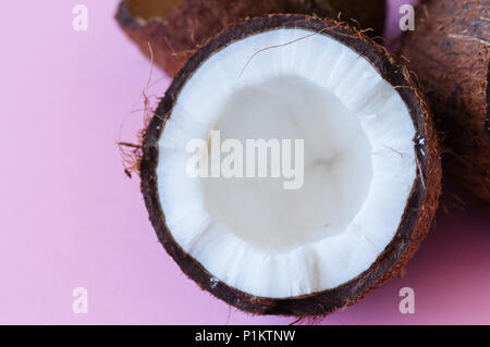 Die Hälfte der Kokosnuss auf rosa Hintergrund. Close Up. Stockfoto