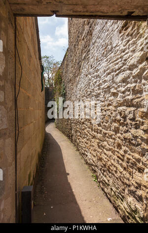 Eine faszinierende Gasse windet sich zwischen den Häusern von Cotswold Stone in der Marktgemeinde in der Long Street Tetbury Gloucestershire, VEREINIGTES KÖNIGREICH Stockfoto