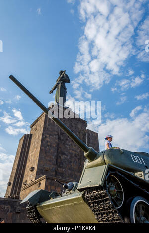 Yerevan, Armenien - 20. August 2017: Kinder spielen auf dem Tank mit Mutter Armenien Denkmal hinter, im Park des Sieges in Eriwan. Stockfoto